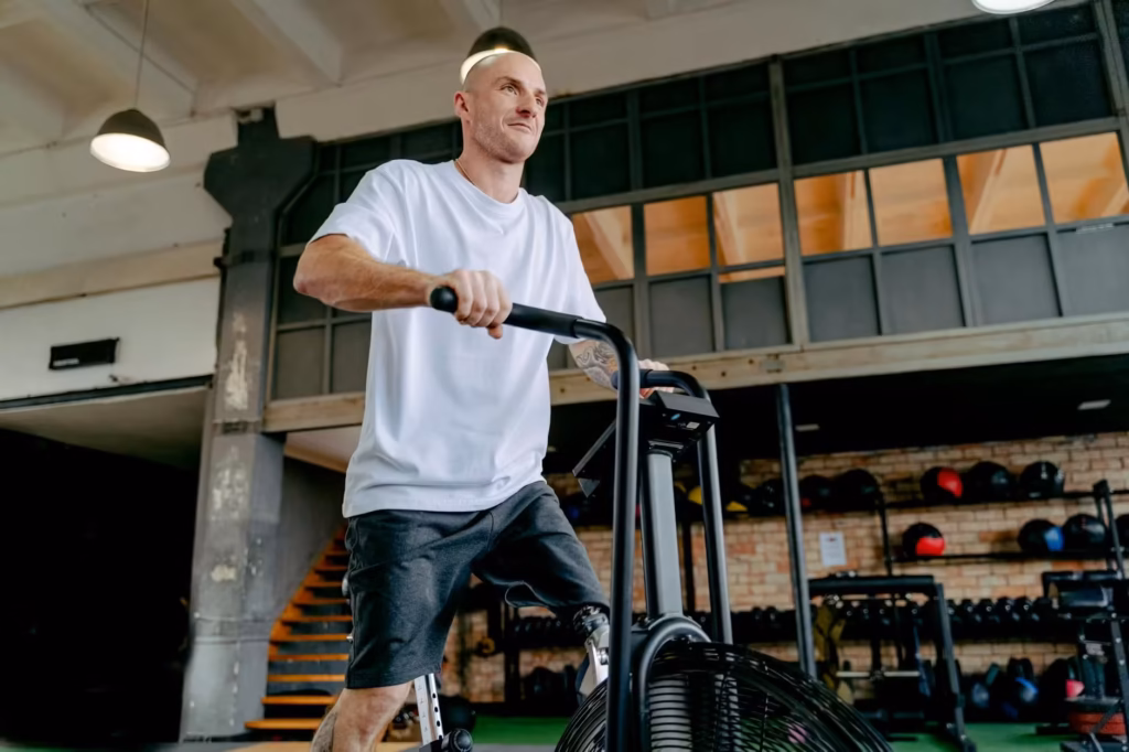 Sportowiec trenujący na rowerze spiningowym.