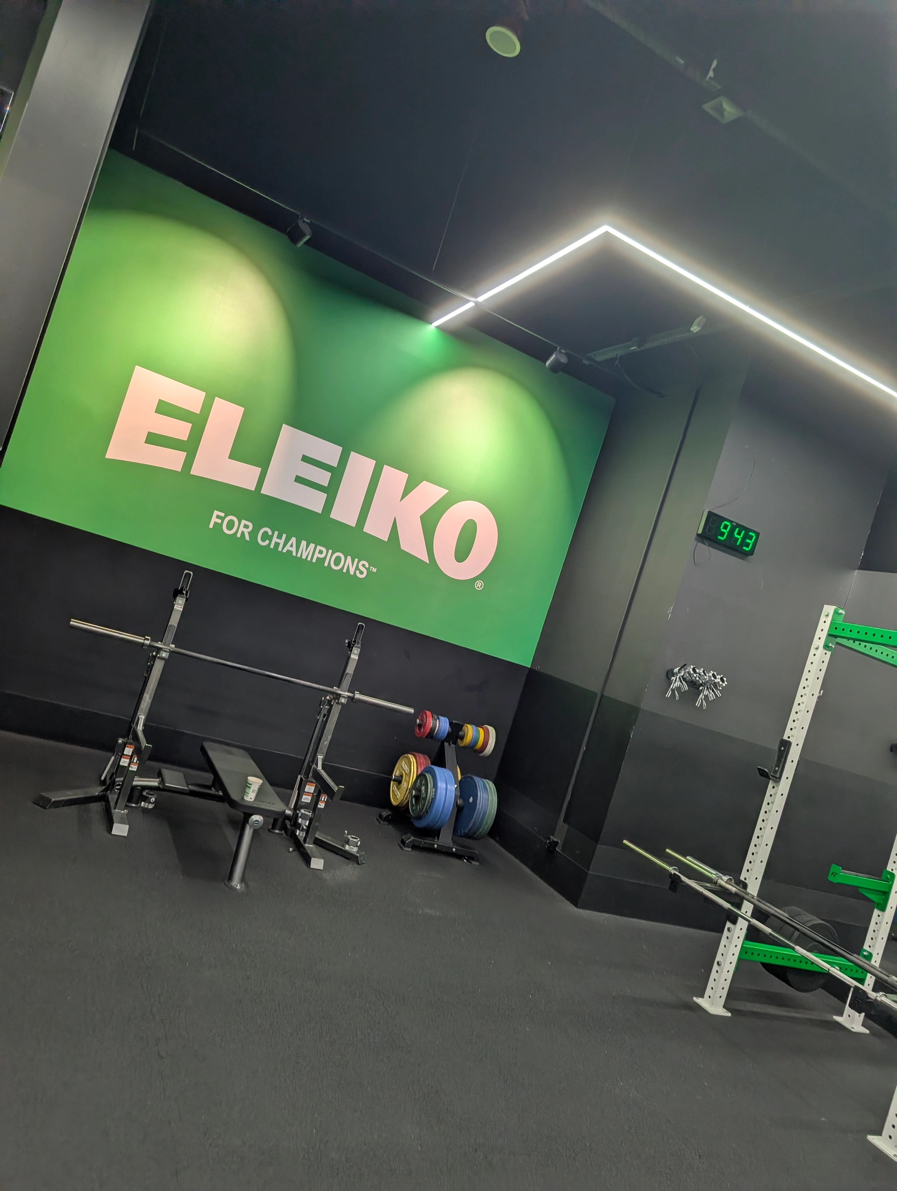 Strefa Eleiko w Endorfinie Mozaika Lublin: stojaki, gryfy olimpijskie i kolorowe obciążenia bumper przy ścianie z logo Eleiko For Champions