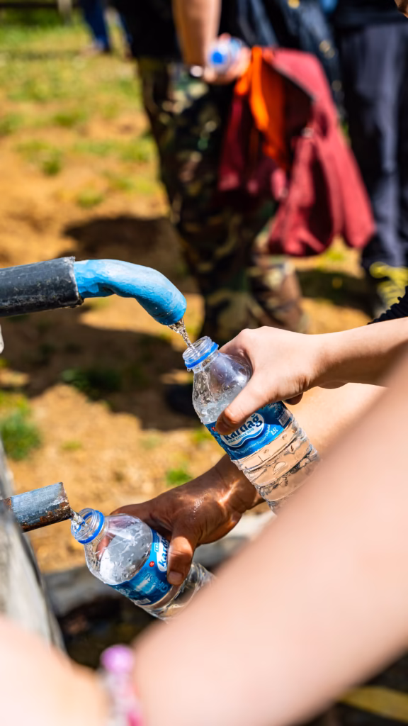 Napełnianie plastikowych butelek wodą z ulicznego kranu